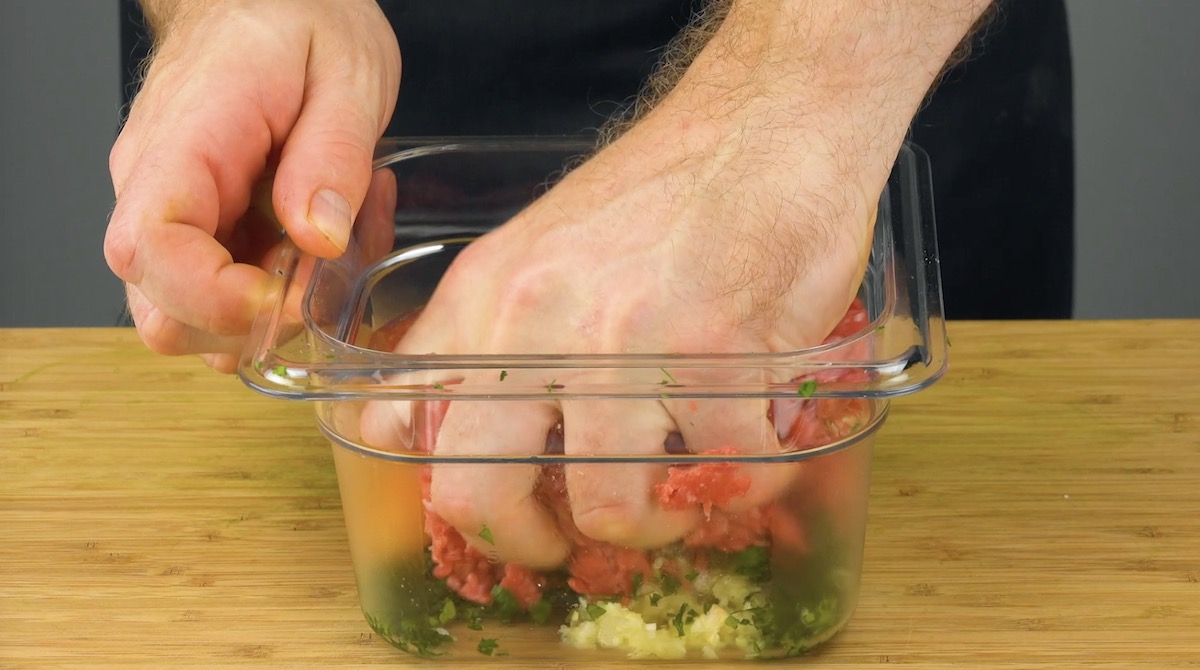 Hackfleisch wird mit Gewürzen und Ei verknetet