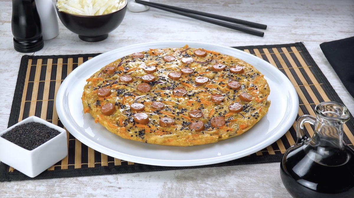 Chinakohl-Frittata auf Teller mit Würstchen, die wie eine Salami-Pizza aussieht