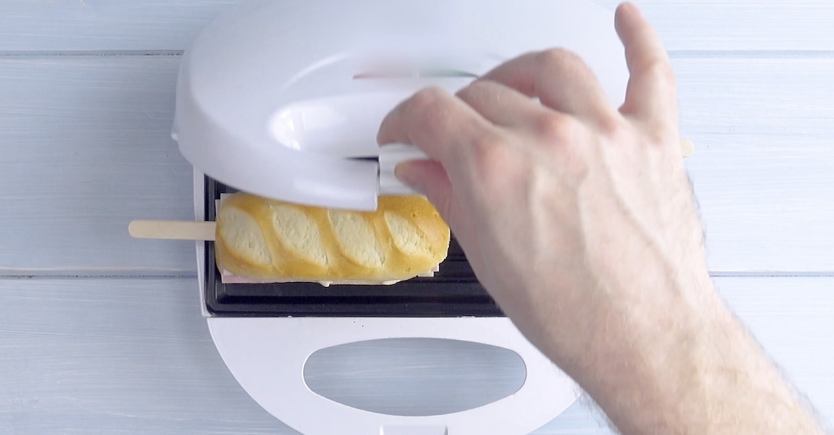 Die Milchbrötchen am Stiel werden im Sandwichtoaster gebacken.