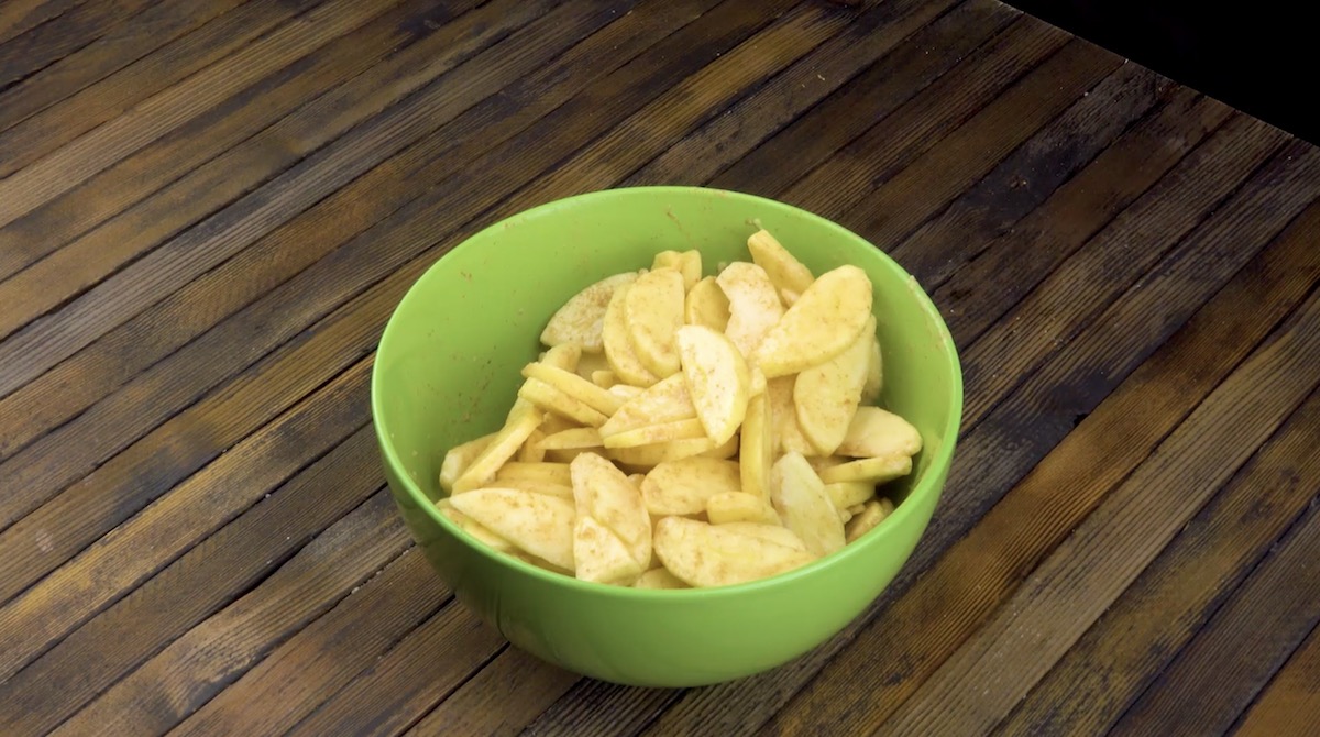 Apfelspalten und Zimt in einer grünen Schüssel