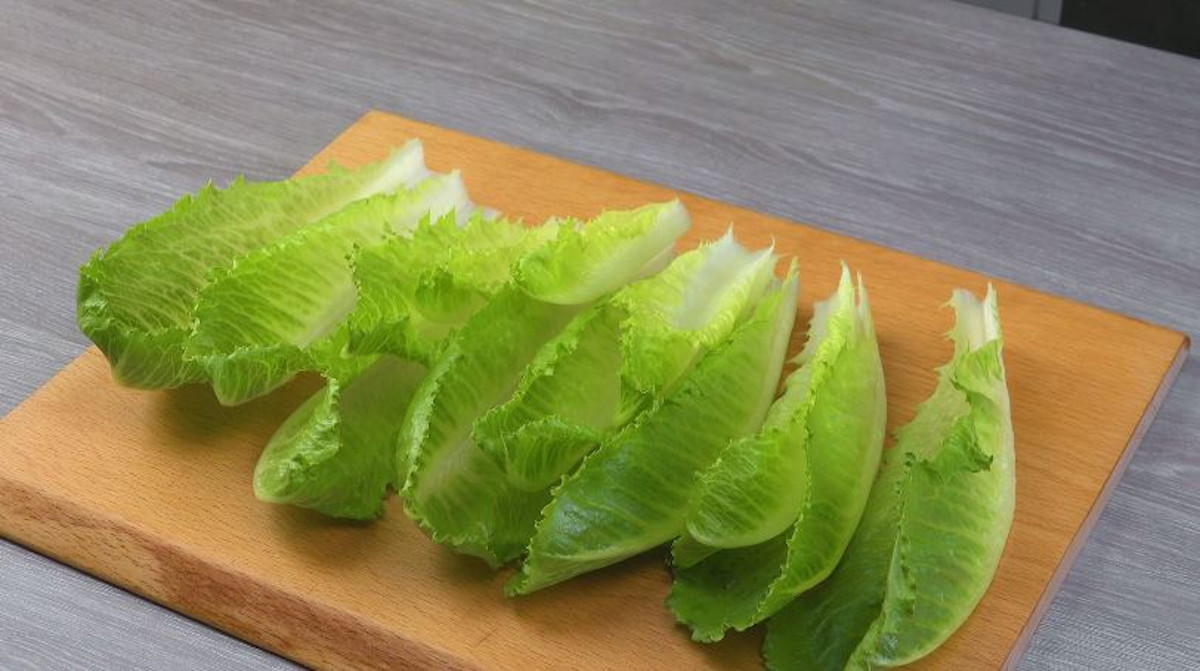 Einzelne Salatblätter auf holzbrett