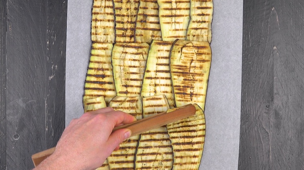 Angebratene Auberginenscheiben werden auf Backpapier zu „Bett“ gelegt