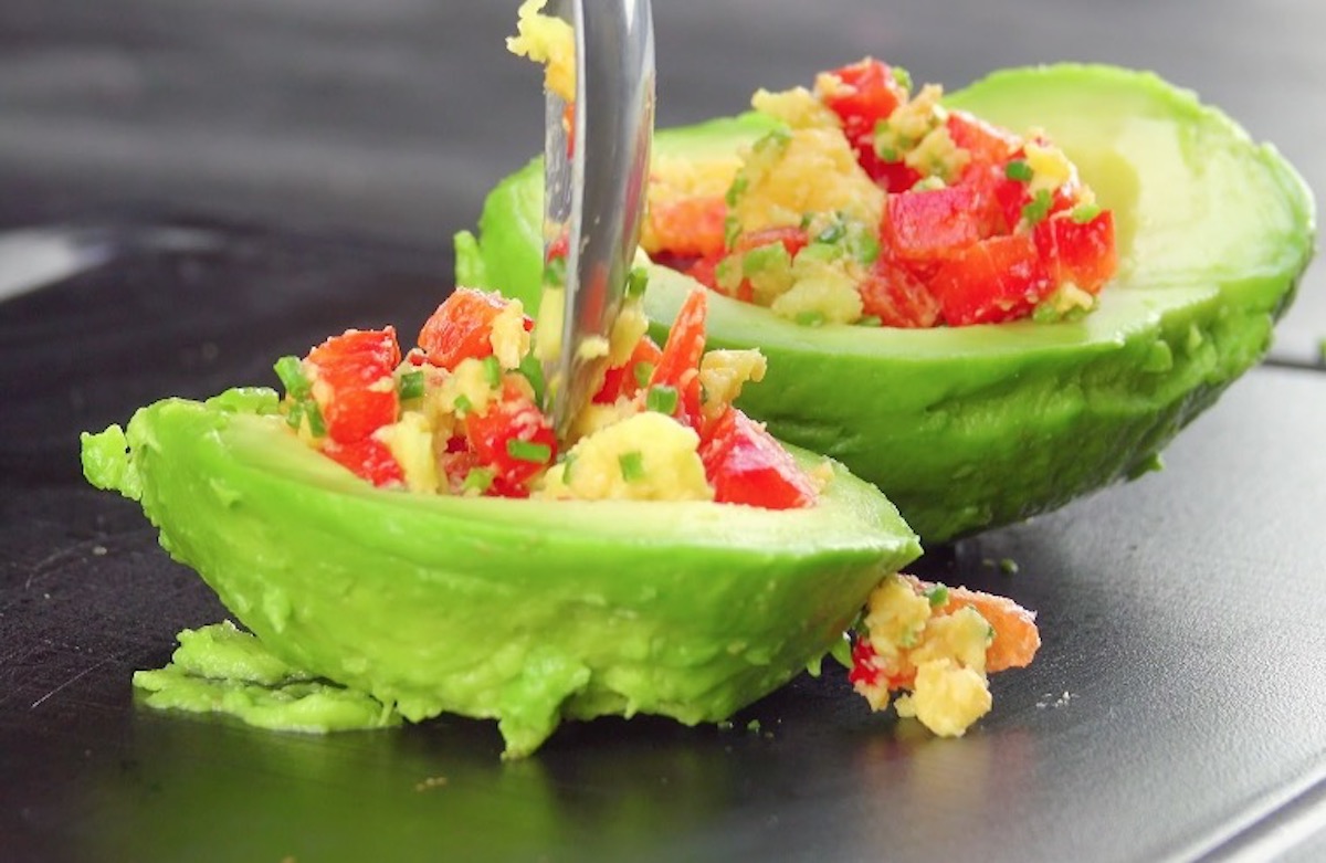 Avocadohälften werden mit Paprika und Cheddar gefüllt