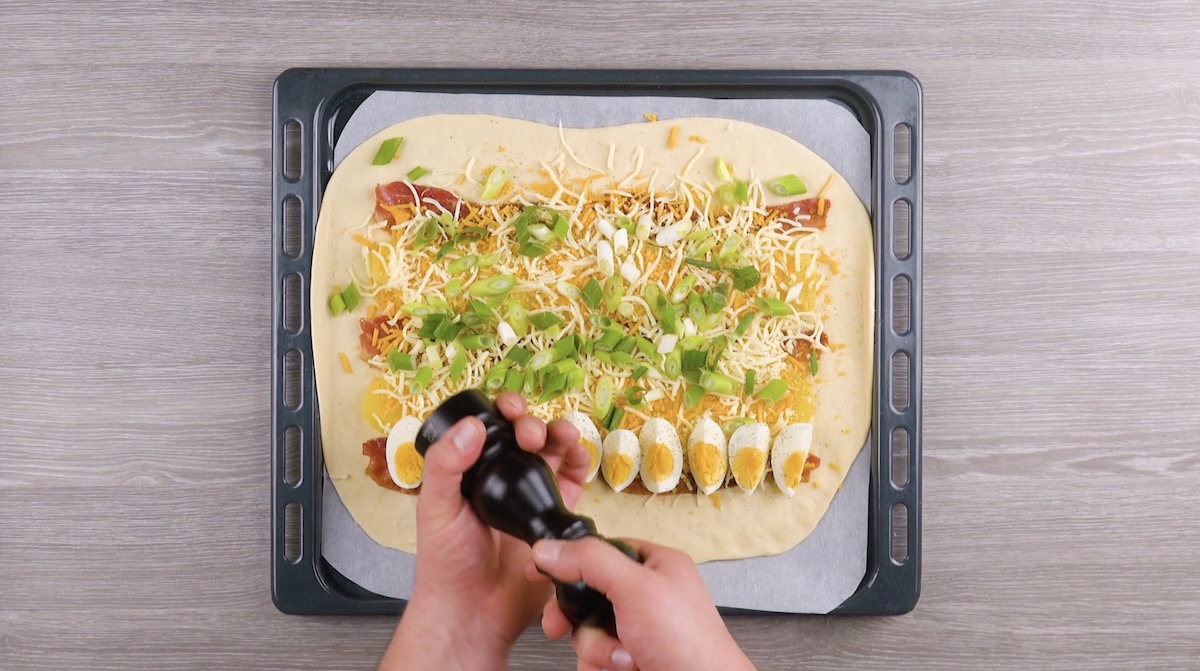 Pfeffer aus Pfeffermühle wird über Bauernfrühstück verteilt