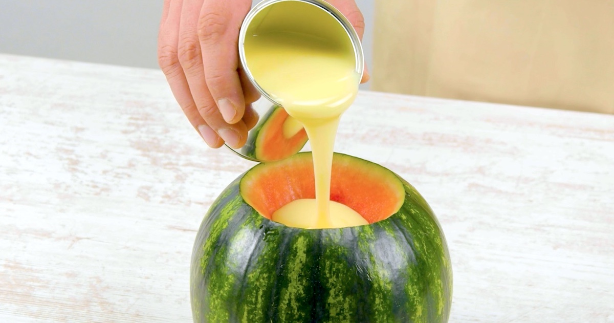 Wassermelone wird kraterförmig aufgeschnitten und mit Kondensmilch gefüllt