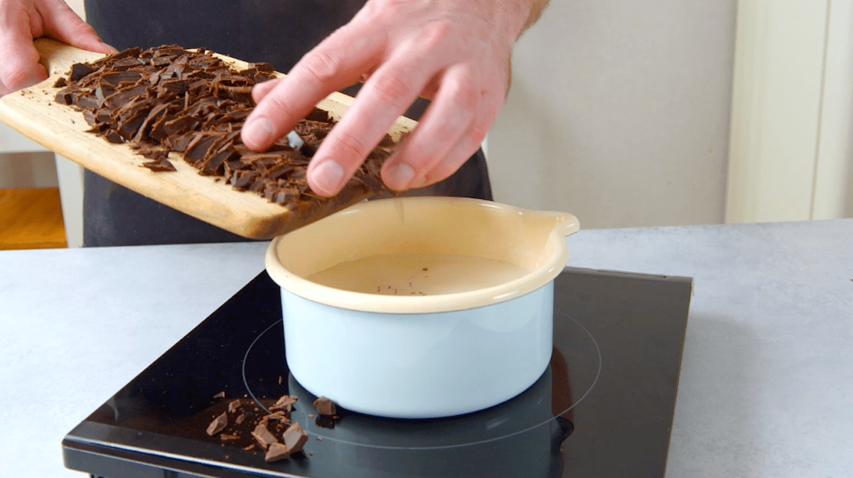 Klein gehackte Schokolade wird in heiße Milch. gegeben