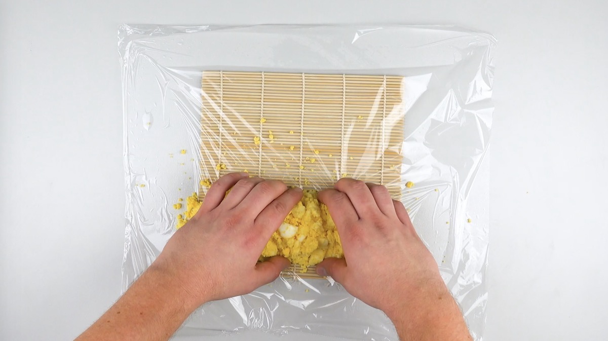 Eiweiße und Eigelbe werden vermengt und auf Frischhaltefolie auf einer Sushimatte gelegt