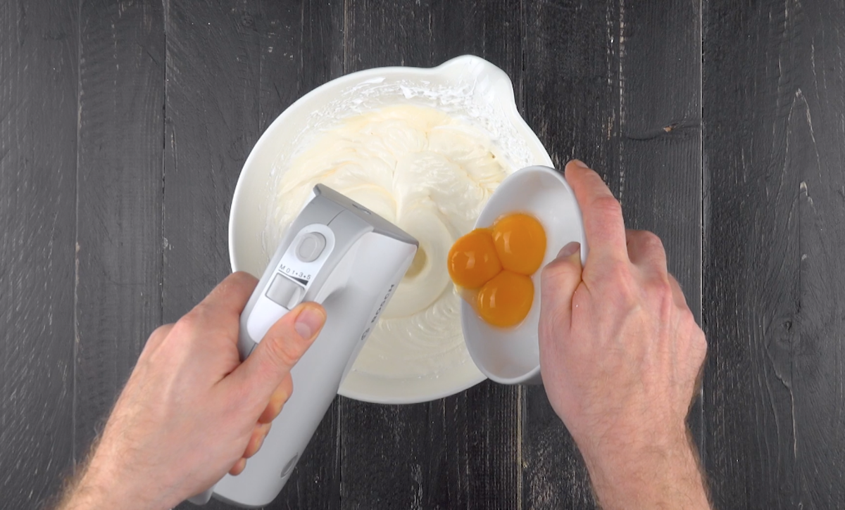 3 Eigelbe werden zu geschlagenem Eiweiß in Schüssel gegeben