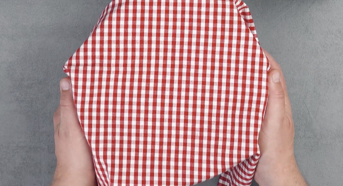 Hefeteig in Schüssel wird mit Geschirrtuch abgedeckt