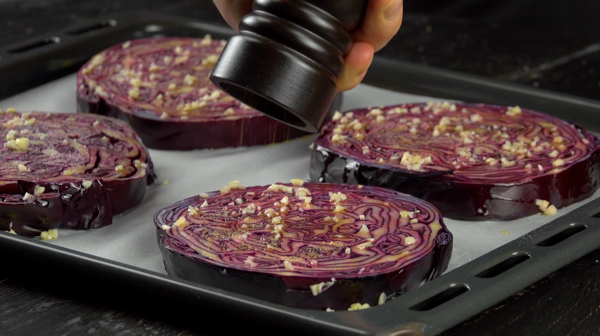 Rotkohlscheiben werden mit Knoblauch und Salz und Pfeffer gewürzt