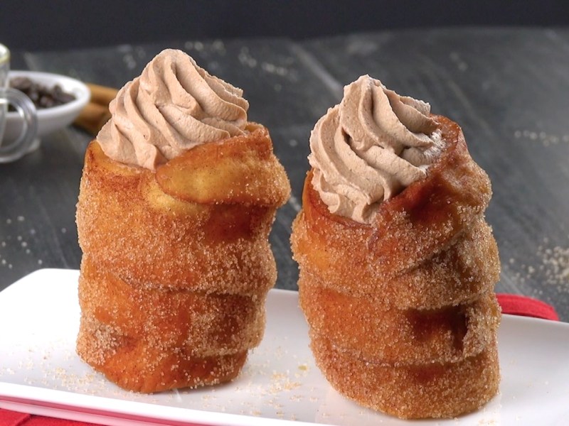 2 Zimtrollen mit Kaffee-Mousse gefüllt auf einem Teller.