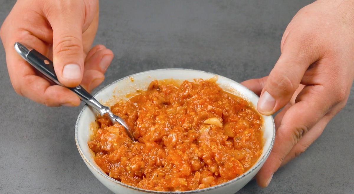 Klein gehackte Tomaten, Zwiebel, Knoblauch und Salsiccias werden in Schüssel mit Öl vermengt