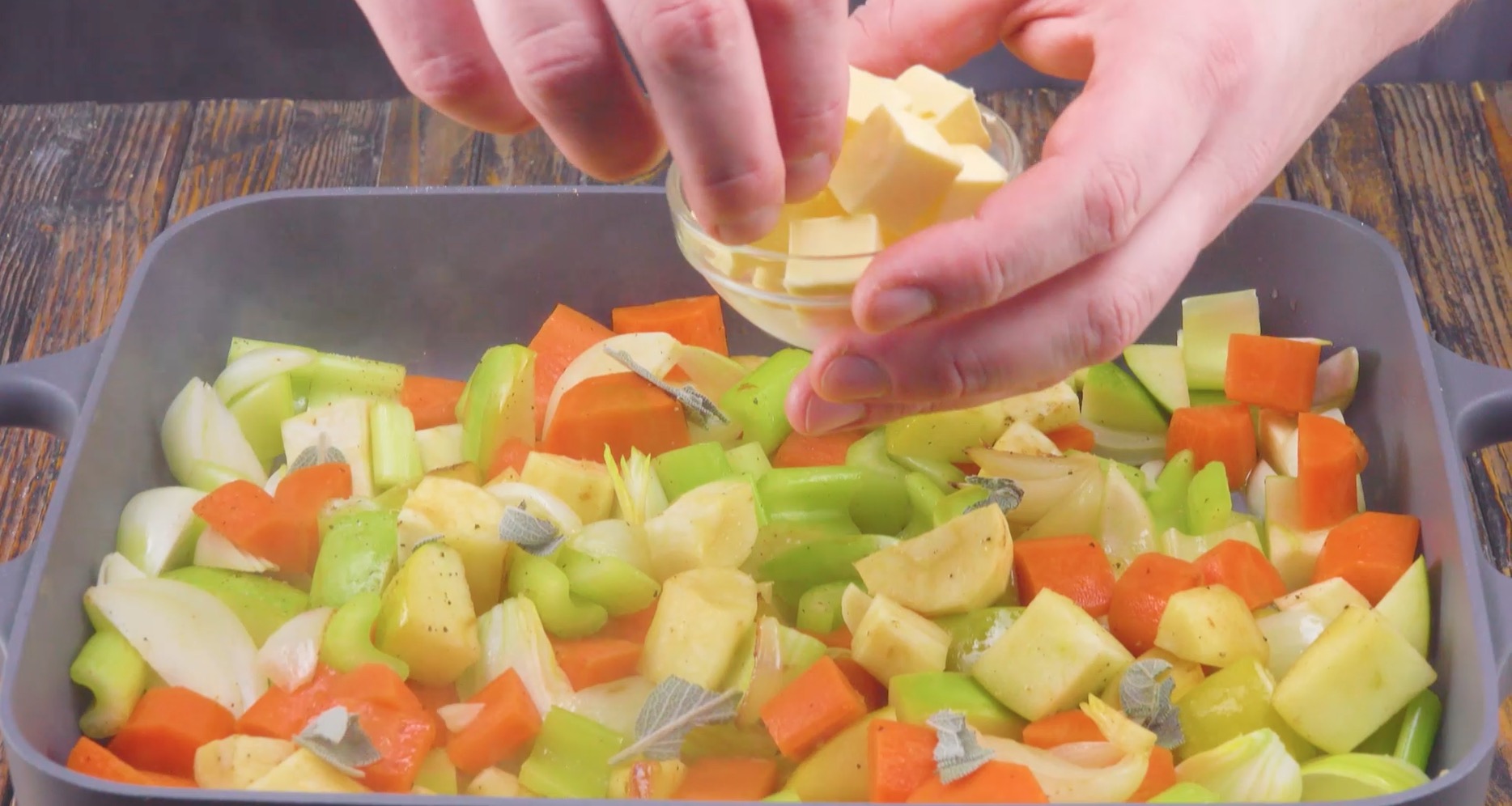 Gemüse wird in Würfel geschnitten und in einen Bräter gegeben.