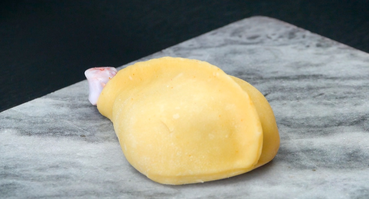 Hähnchenkeule wird mit Teig ummantelt