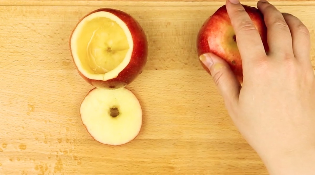 Zwei Äpfel werden ausgehöhlt, um später als Trinkgefäß zu dienen