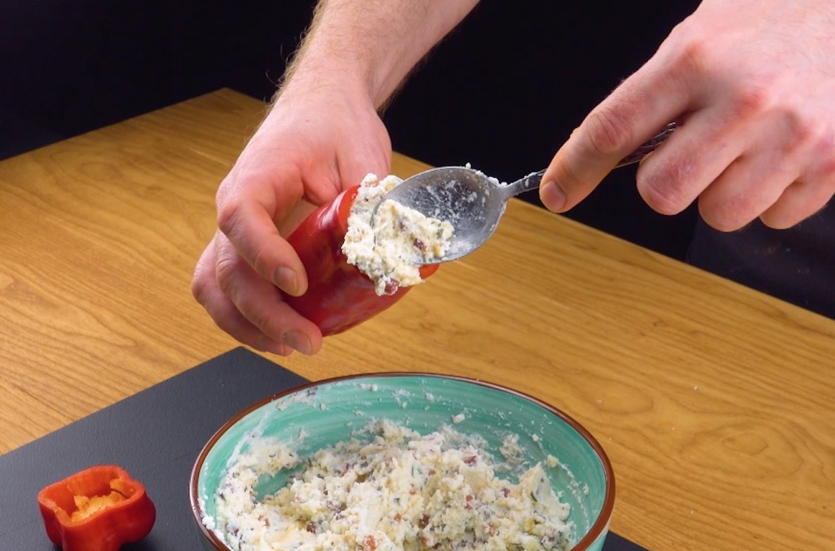 Rote Paprika wird mit Frischkäse-Füllung gefüllt