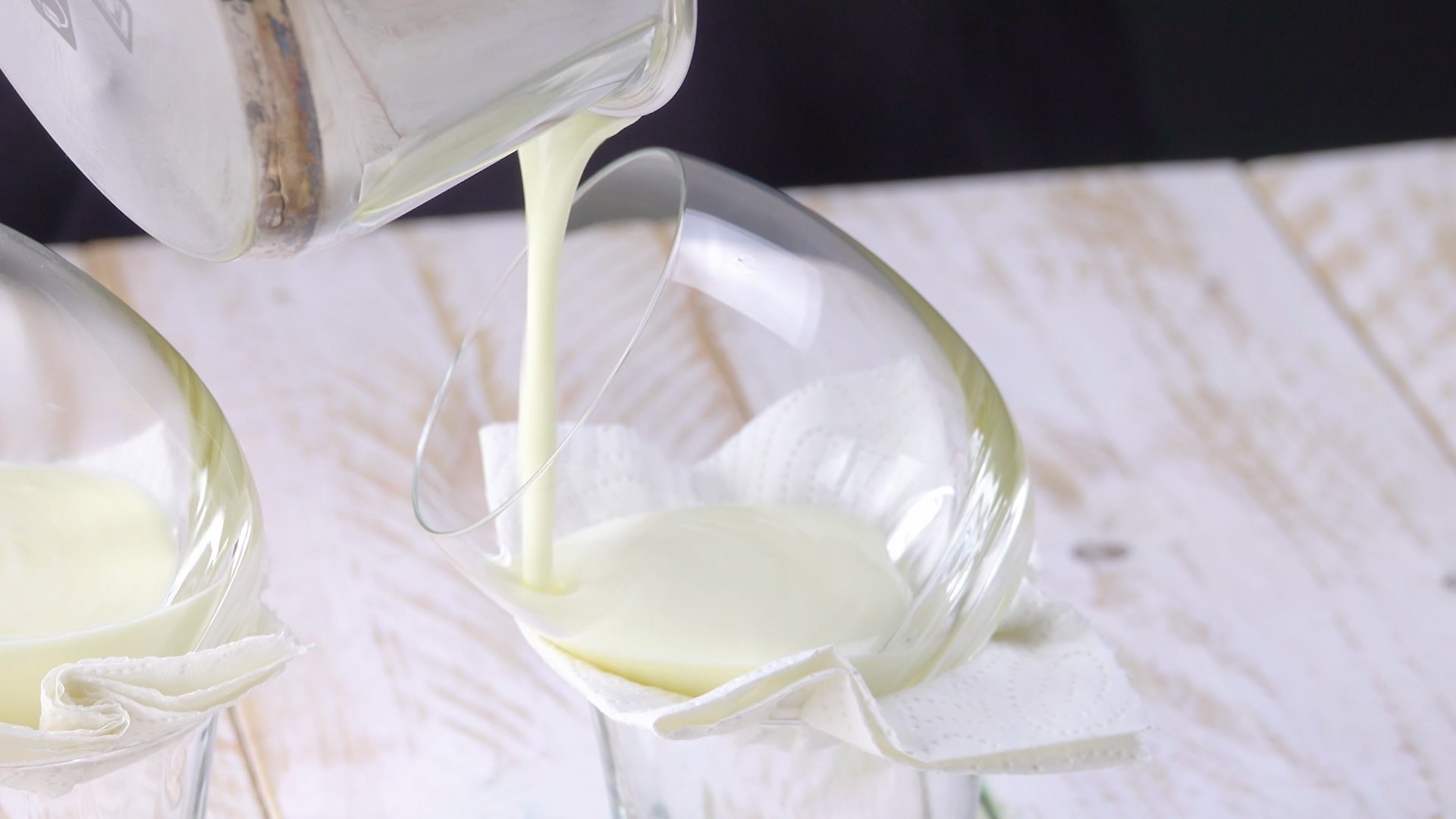 Weiße Pannacotta wird schräg in Dessertglas gegossen