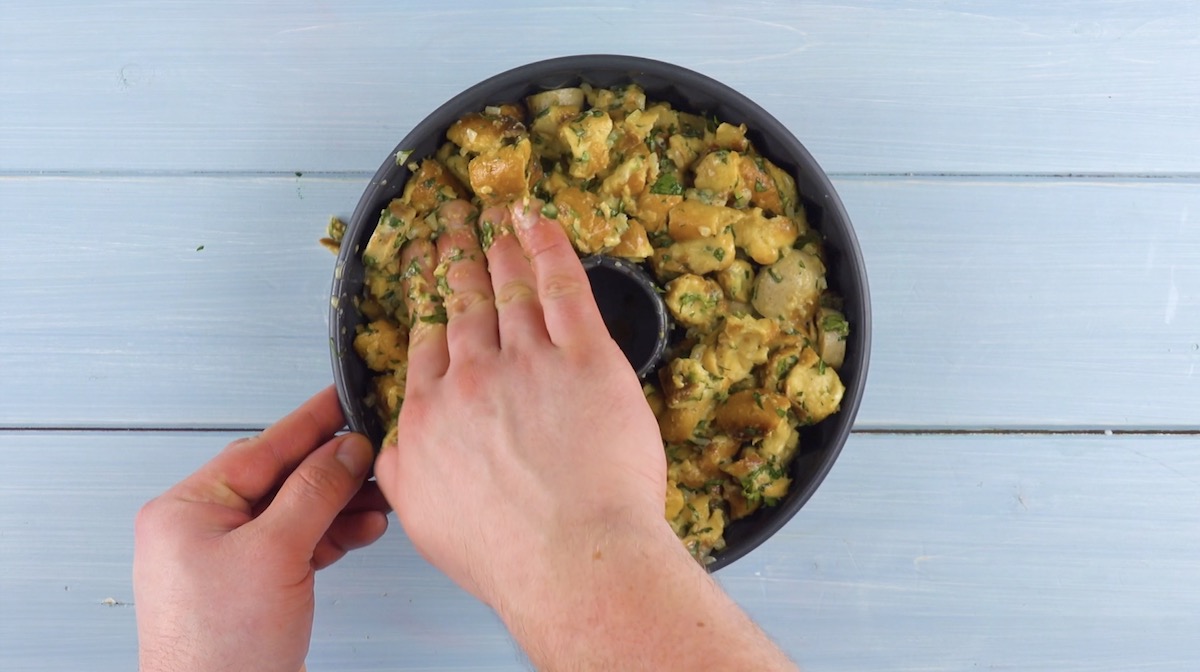 Brezel- und Bratwurststücke werden in Gugelhupfform gefüllt