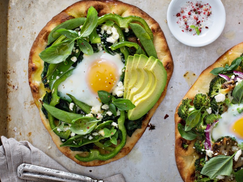 Zwei Frühstückspizzen auf einem Blech mit Backpapier.