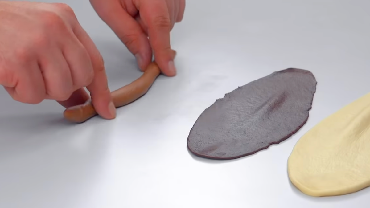 2 flach ausgerollte Teigrollen und eine zur Schlange ausgerollte Teigrolle