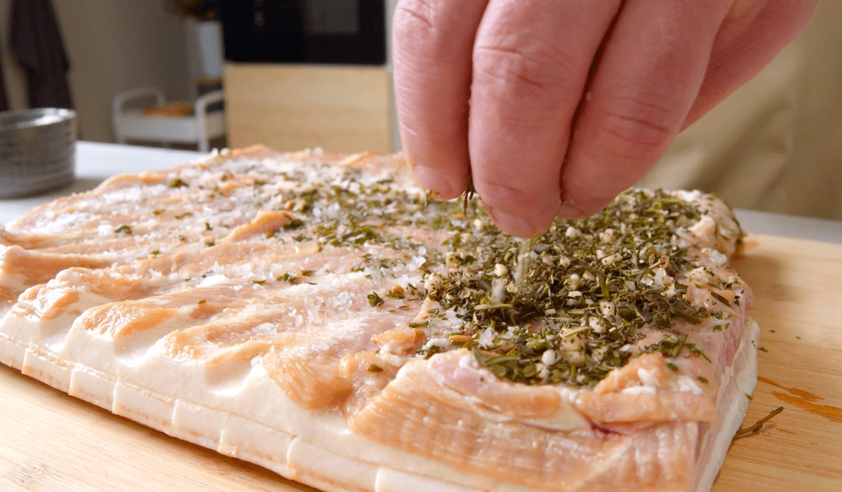 Schweinebauch wird mit Kräutern mariniert
