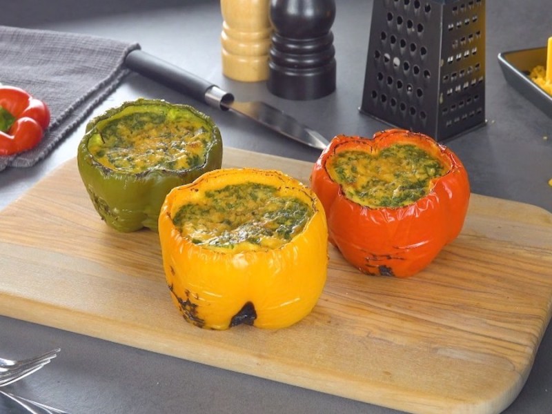 5 Ideen für Eier auf dem Grill: mit Ei gefüllte Paprikaschoten auf einem Holzbrett.