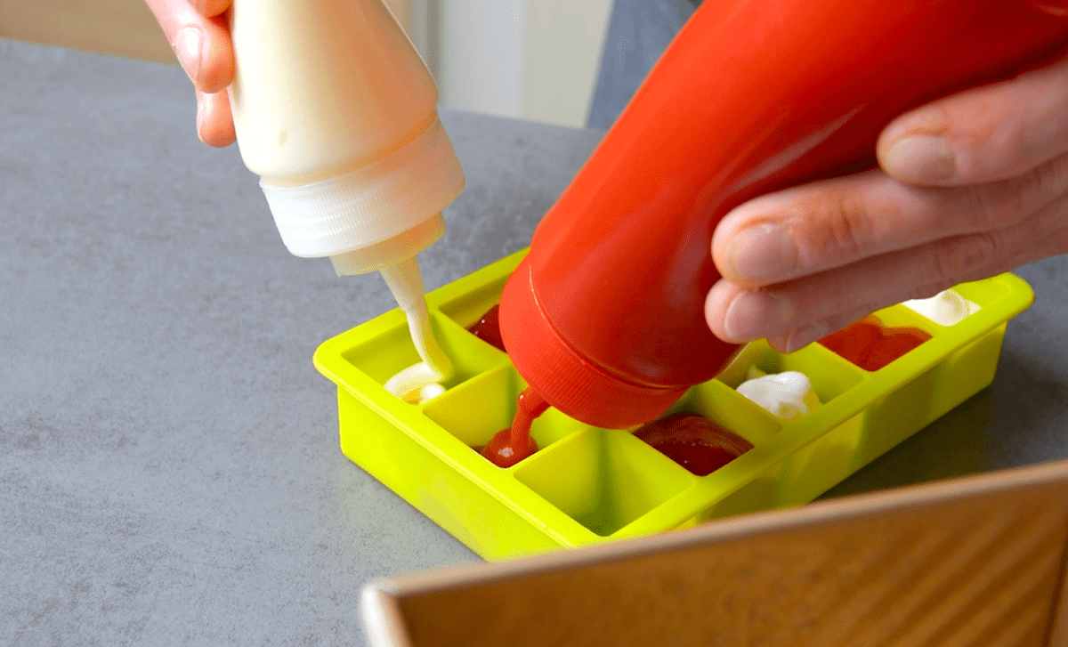 Ketchup und Mayonnaise werden in eine Eiswürfelform gegeben