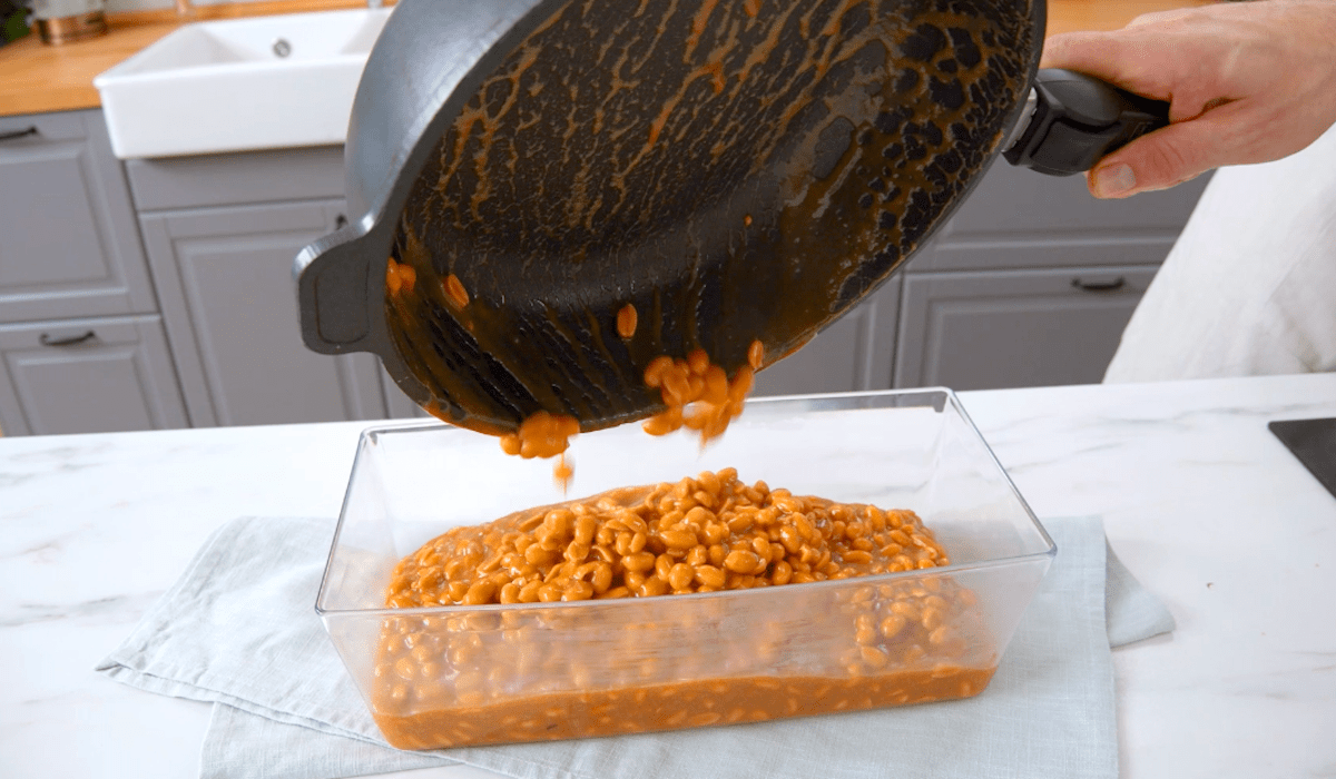 Eine Masse aus Karamell und Erdnüssen wird in eine Kastenform gegeben