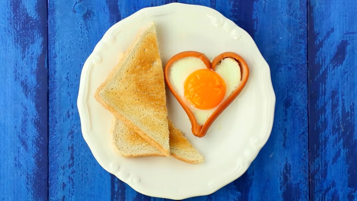 Würstchen in Herzform mit Spiegelei gefüllt, dazu 2 halbierte Toasts