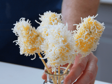 Vier Käsespieße stehen in einem Glas.