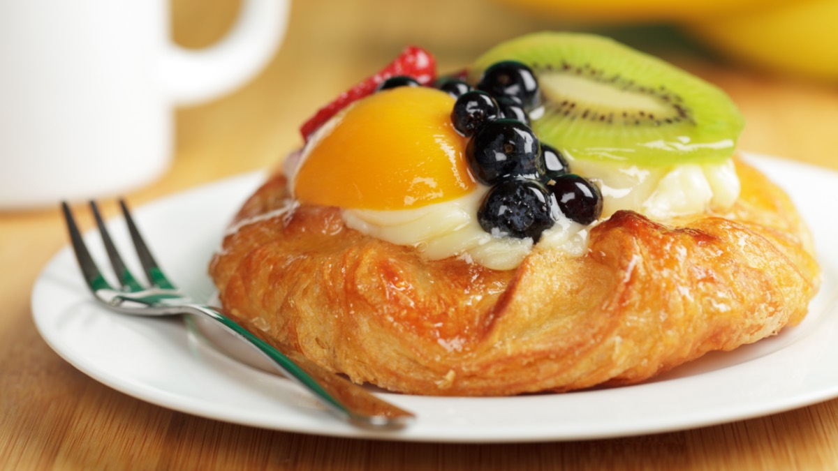 Ein Plunderteilchen mit Vanillepudding und frischen Früchten auf einem Teller