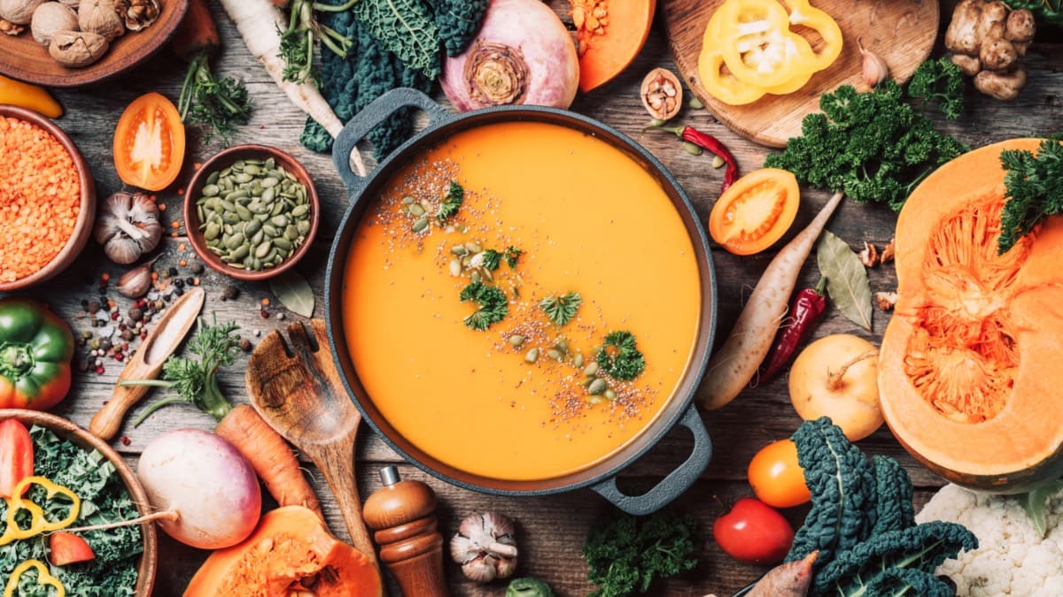 Herbstgemüse um einen Topf mit Kürbissuppe