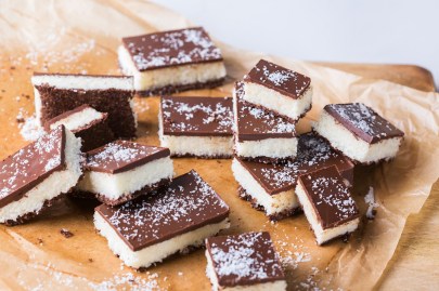 Mehrere Kokos-Schnitten mit Schoko-Glasur auf Backpapier