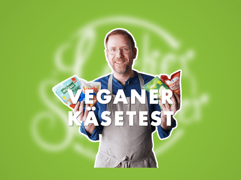 Koch hält 4 vegane Reigekäse-Tüten in den Händen, grüner Hintergrund, um Vordergrund steht 