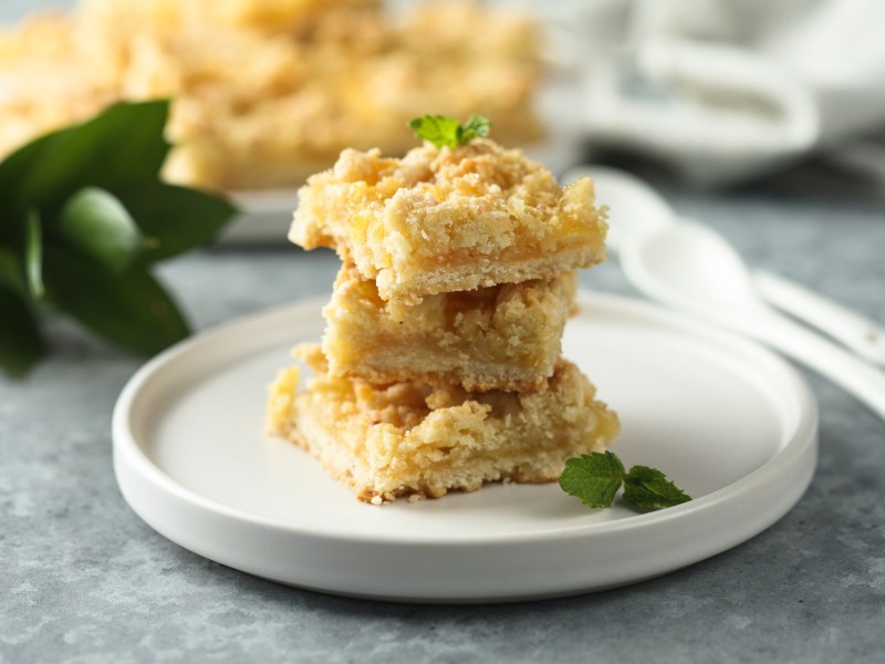 Drei stück Zitronen-Streuselschnitten auf einem Teller.
