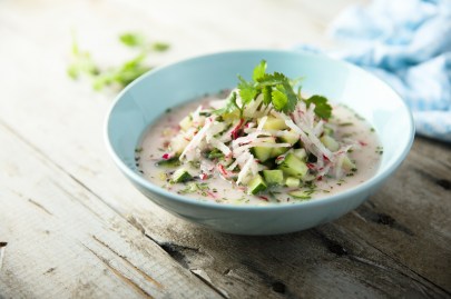 Ein Teller Radieschensuppe mit Frischkäse und Gurke.