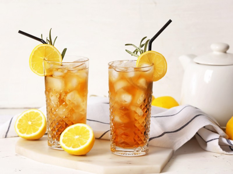 Zwei Gläser Kräuter-Eistee, garniert mit Zitrone und Rosmarin