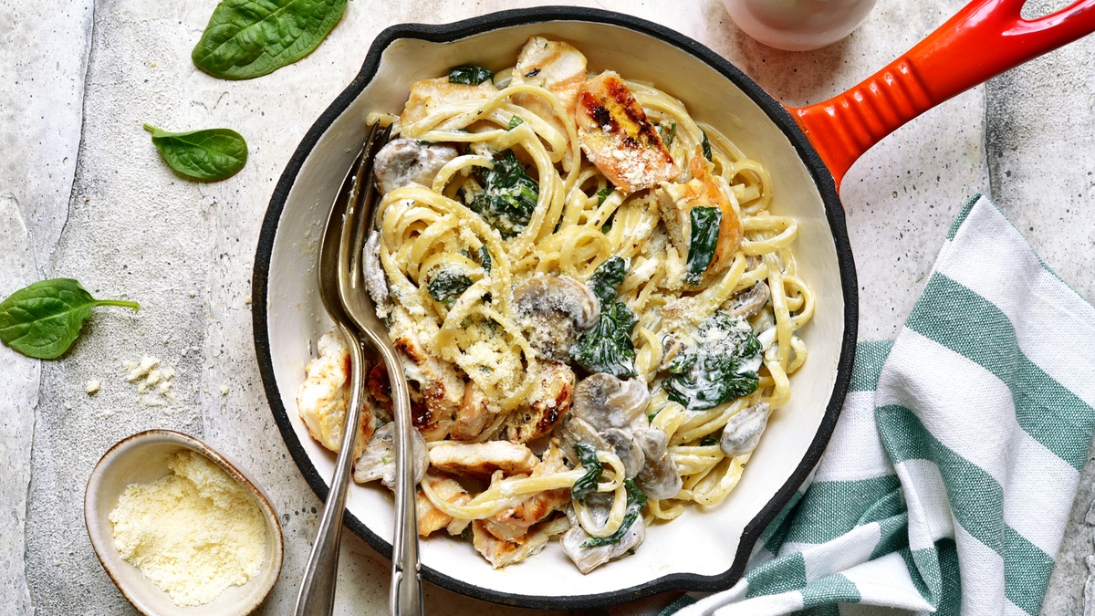 Nudel-Hähnchen-Pfanne auf hellem Hintergrund.