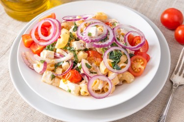 Teller mit warmem Nudelsalat mit Tomaten
