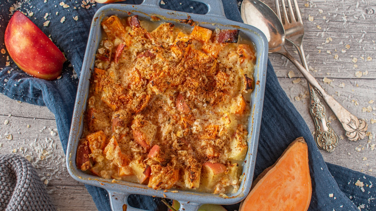 Apfel-Süßkartoffel-Auflauf in einer blauen Auflaufform.