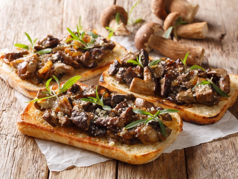 Steinpilz-Toast auf einem Holztisch.