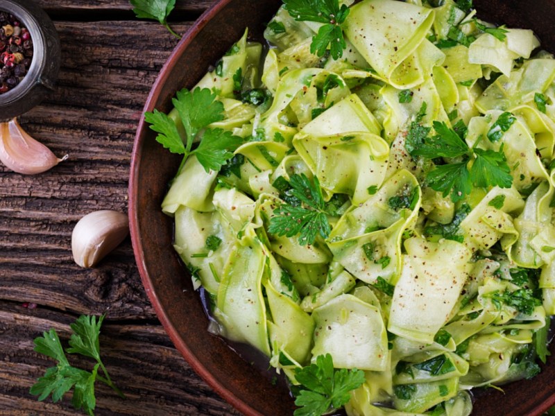 Eine Schüssel mit mariniertem Zucchini-Salat in der Draufsicht.