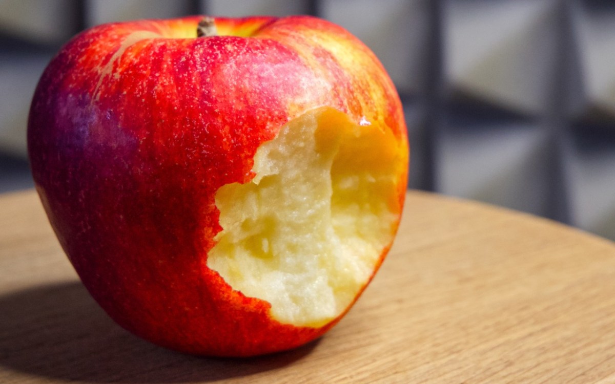 Wie viele Äpfel am Tag: ein angebissener Apfel auf einer Tischplatte.