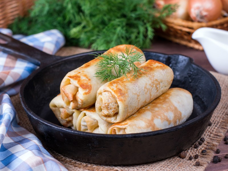 Eine Pfanne mit Pfannkuchen mit Reis-Pilz-Füllung.