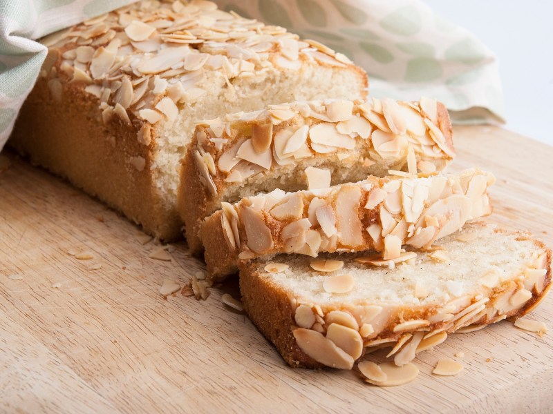 angeschnittener Mandel-Marzipan-Kuchen auf einem Küchenbrett