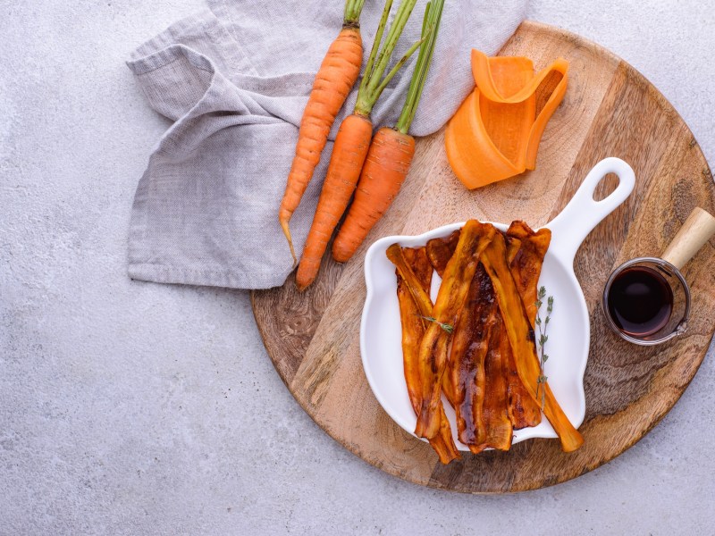 Möhren-Bacon in einer Porzellanschale, daneben Zutaten.