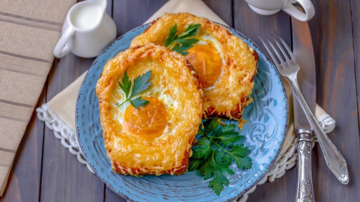 Zwei Spiegelei-Toasts auf einem blauen Teller.