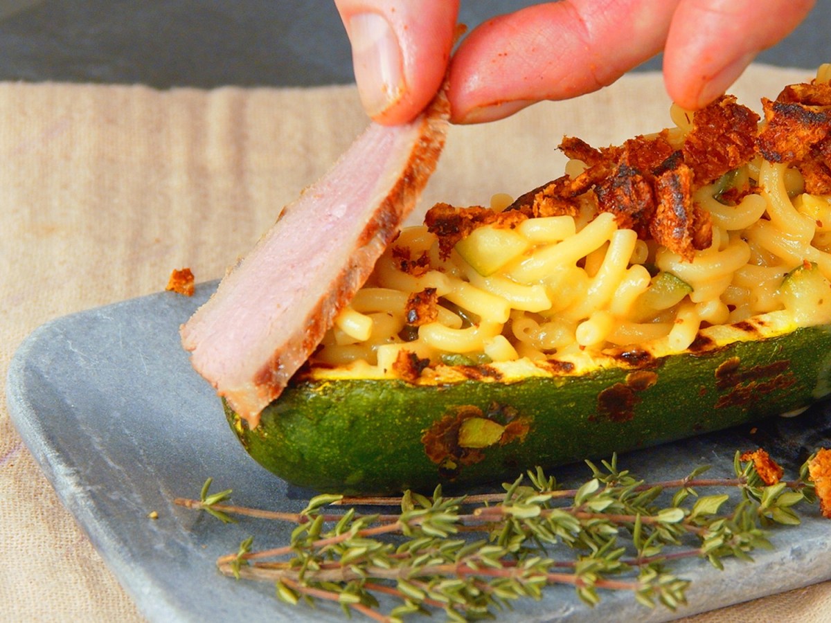 Gefüllte Zucchini mit Nudelrisotto und Entenbrust auf Teller