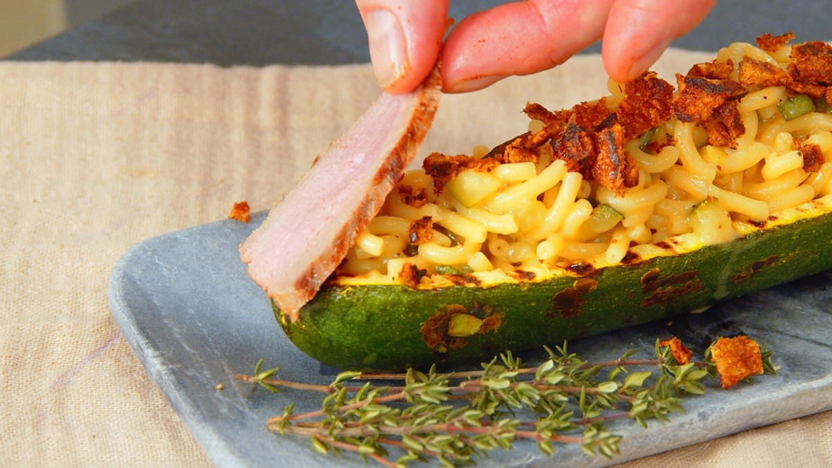 Gefüllte Zucchini mit Nudelrisotto und Entenbrust auf Teller