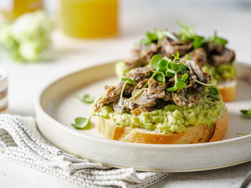 Avocado-Toast mit gegrillten Champignons auf einem Teller